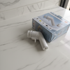 White handheld cleaning brush with packaging on a marble surface