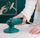 Person using a green handheld sander on a white surface with a close-up inset showing the tool's head.